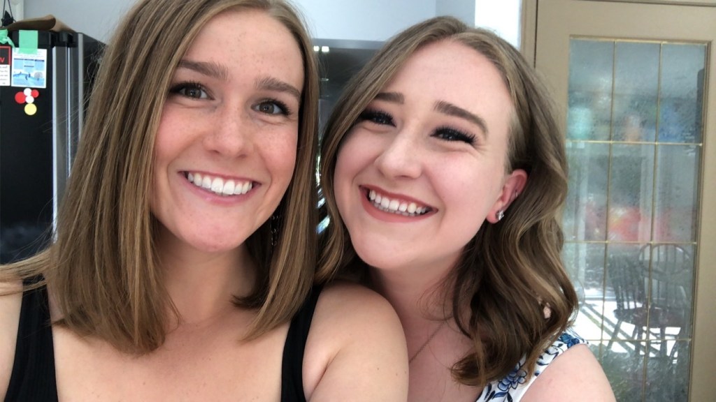 Two young adult sisters smiling with heads together. Dental cleanings, dental hygiene, oral health, white teeth