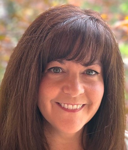 Wendy Horler dental hygienist smiling in backyard amongst autumn background. Dental cleanings, dental hygiene, oral health